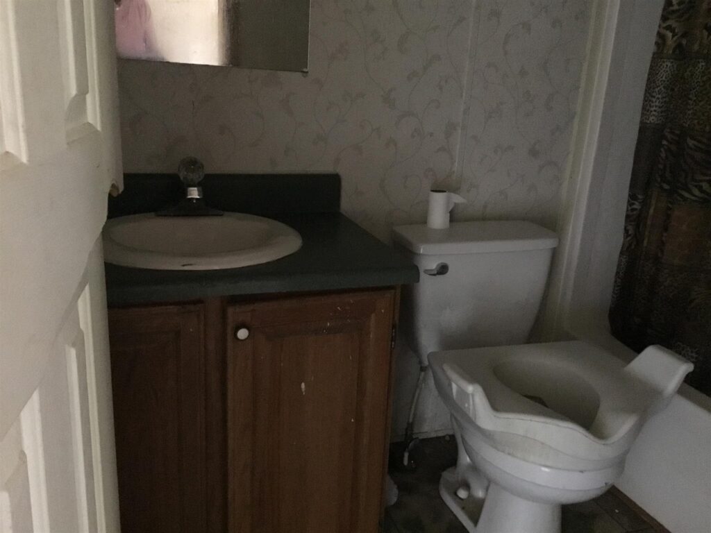 Image of outdated bathroom with strange toiled seat adaptation